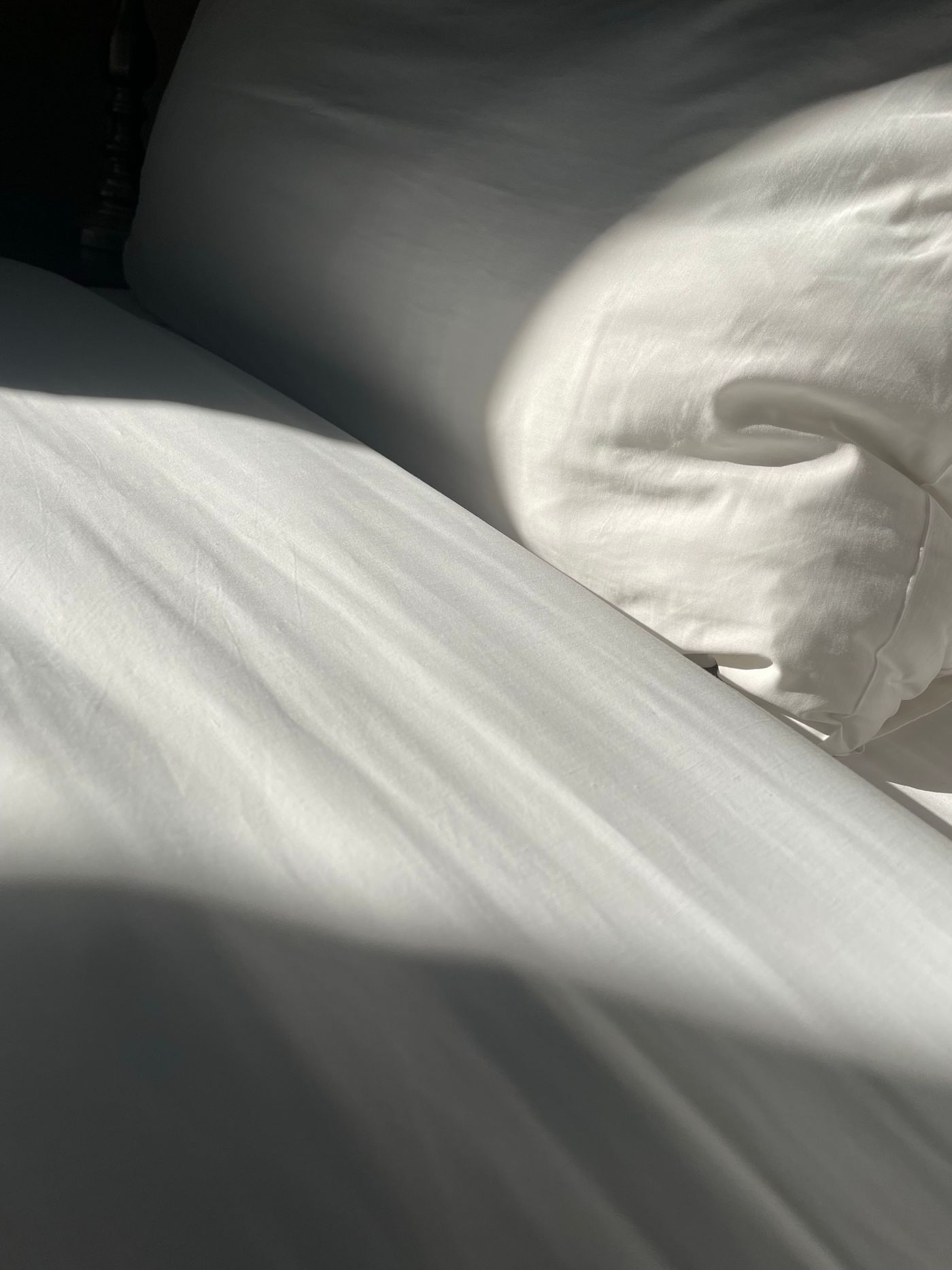 Morning light across crisp white bed linens